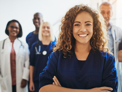 Smiling Female Doctor Standing With Medical Staff In A Hospital